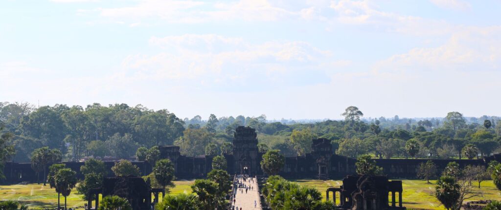 Widok z górnego tarasu Angkor Wat na monumentalną bramę i otaczającą kompleks zieloną dżunglę Kambodży.